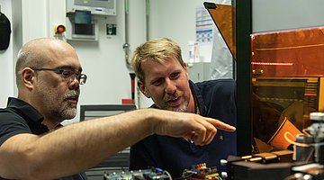 Prof. Jochen Guck und Dr.-Ing. Jens Langejürgen inspect the setup of their AutoRAPID-Setup