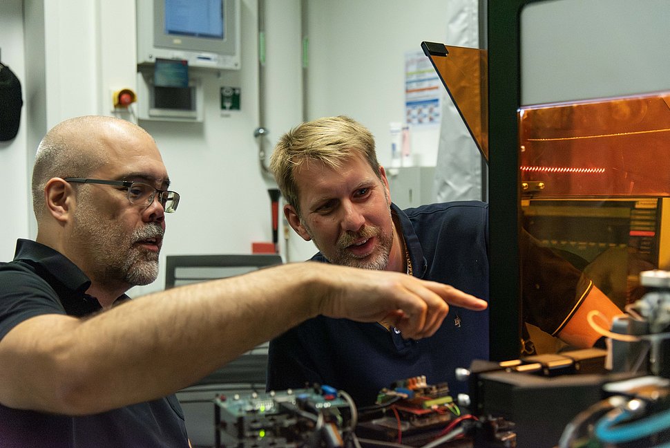 Prof. Jochen Guck und Dr.-Ing. Jens Langejürgen inspect the setup of their AutoRAPID-Setup