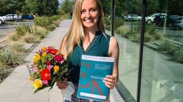 Michelle Küppers mit Blumen und dem Stipendiums-Zertifikat