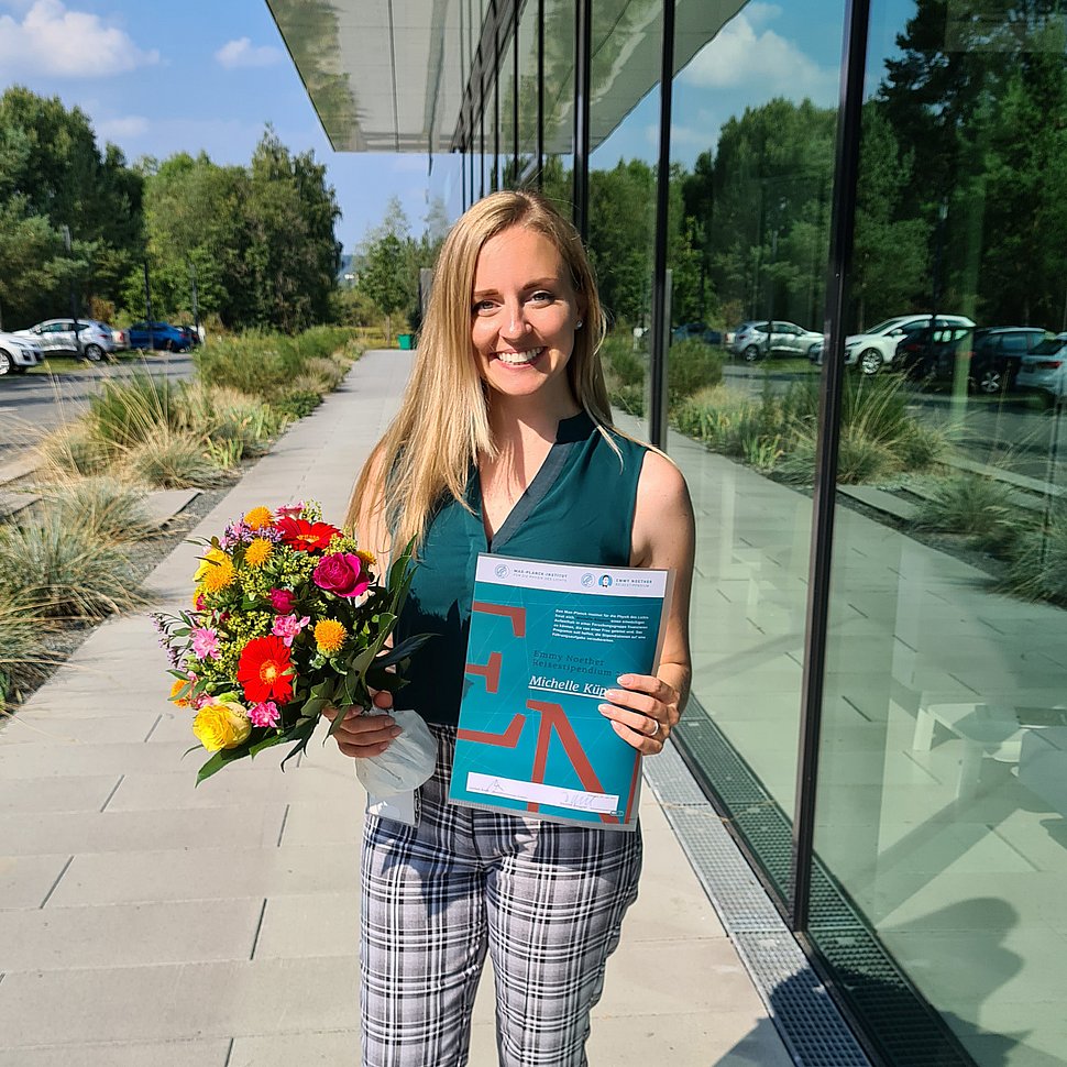 Michelle Küppers mit Blumen und dem Stipendiums-Zertifikat